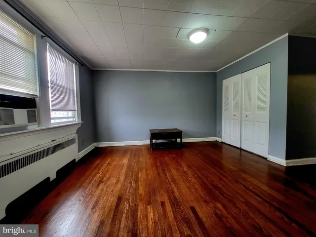 a view of empty room with wooden floor