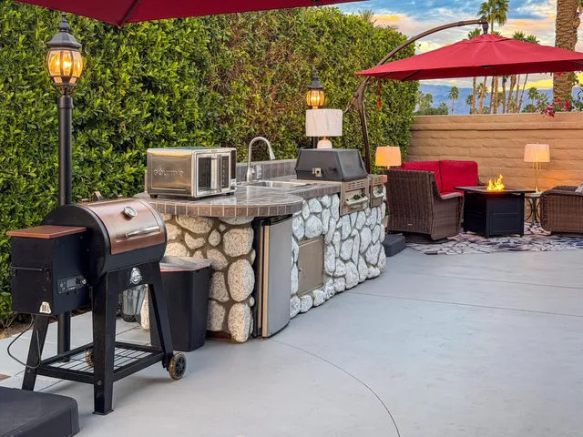 a view of a patio with table and chairs under an umbrella
