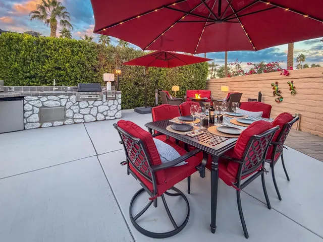 a view of a patio with a dining table and chairs under an umbrella