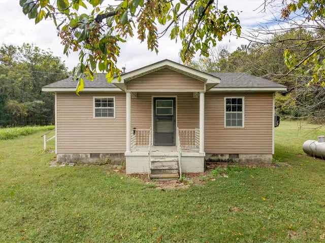 a front view of house with yard and trees
