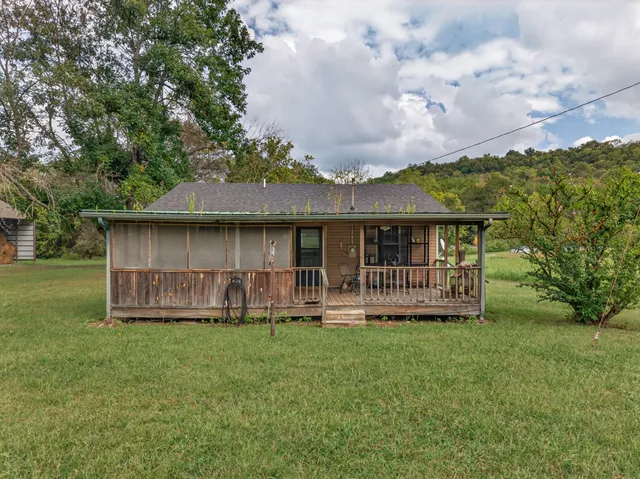 a view of a house with a yard and sitting area