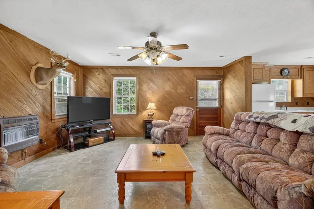 a living room with furniture a flat screen tv and a table