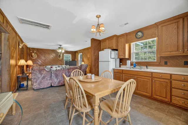 a dining room with furniture a chandelier and window