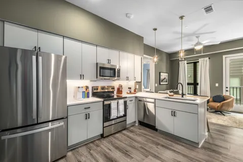 a kitchen with stainless steel appliances a sink cabinets and a refrigerator