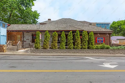 a front view of a house with a yard and potted plants