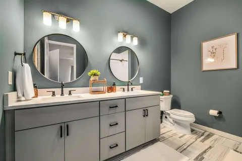 a bathroom with a toilet sink and mirror