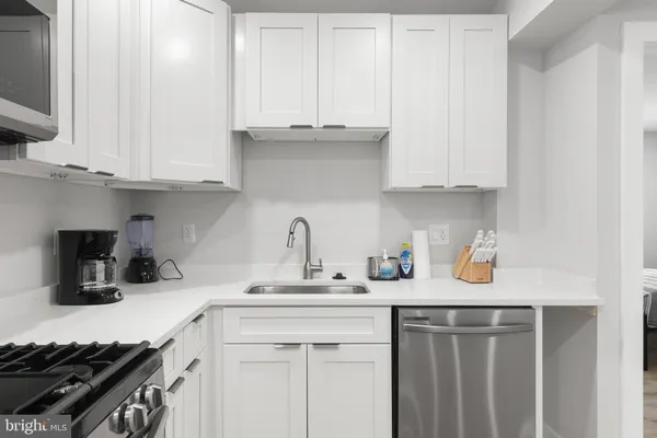 a kitchen with stainless steel appliances granite countertop a sink stove and cabinets