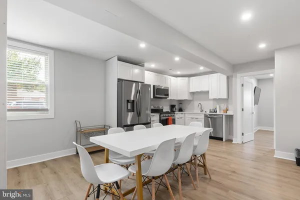 a view of a dining room with furniture a rug a kitchen and chandelier