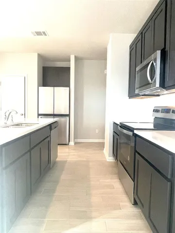 a kitchen with stainless steel appliances granite countertop a sink and a stove top oven