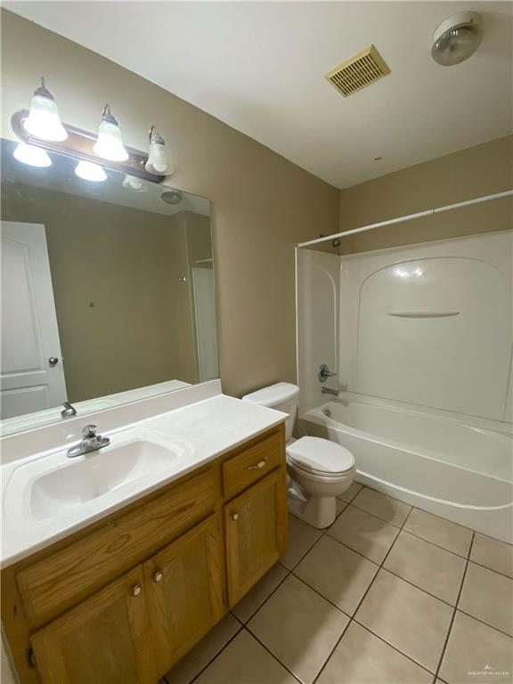 2409 North I Street, Unit G McAllen, TX 78501 - Photo 7 of 10 a bathroom with a toilet a sink a mirror and a bathtub