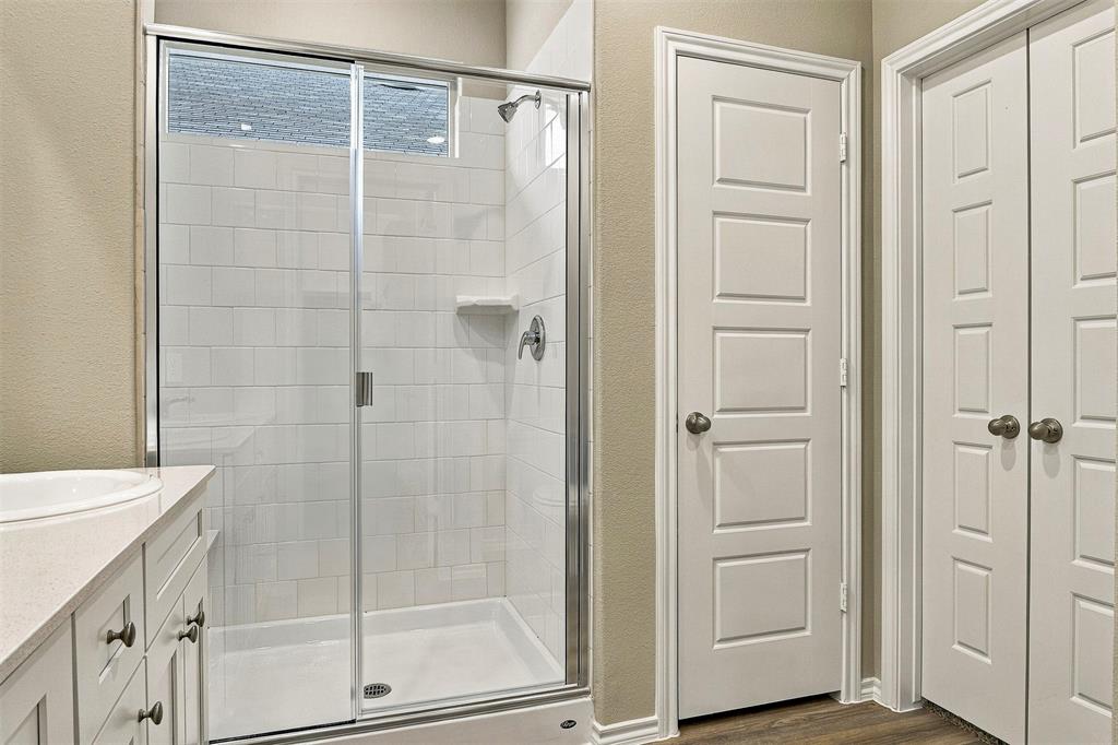 15932 Stableford Road Justin, TX 76247 - Photo 16 of 35 Shower enclosure with clear glass door, white subway tile surround, and built-in shelving