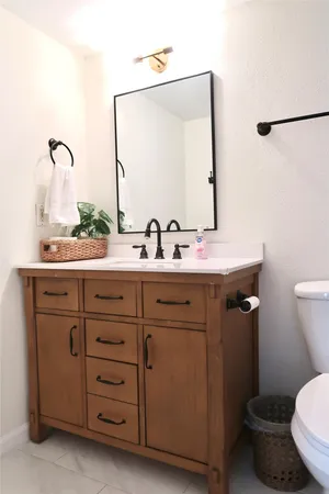 a bathroom with a granite countertop sink a toilet and a mirror