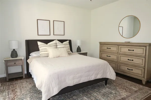 a bedroom with a bed a mirror and night stand