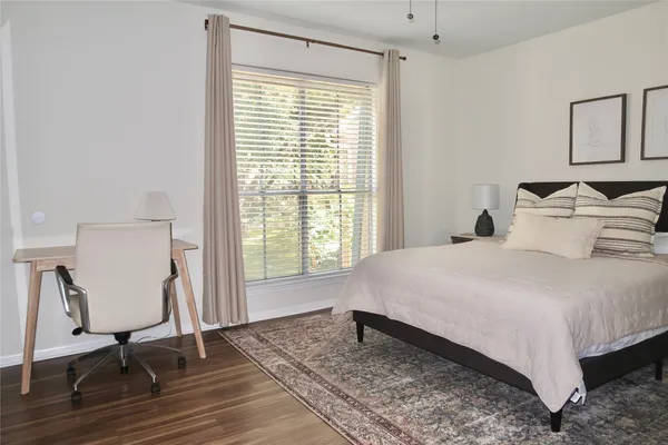 a bedroom with a bed a chair and a large window