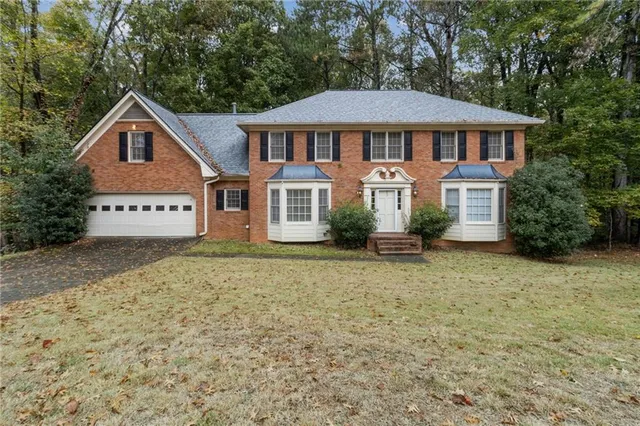 a view of a house with a yard and sitting area