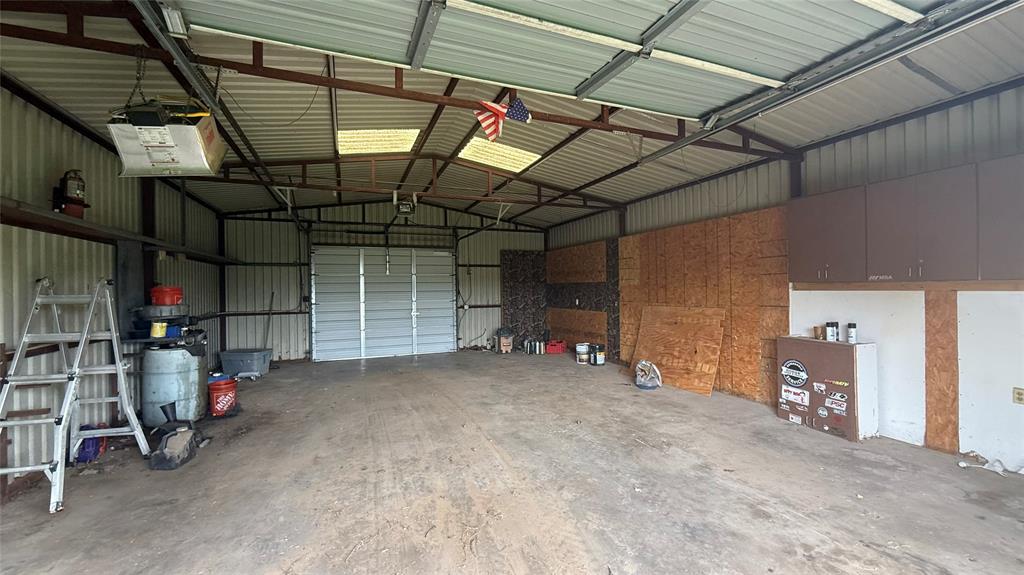 1356 Kerry Lane Azle, TX 76020 - Photo 26 of 27 Spacious metal outbuilding featuring a corrugated metal roof, corrugated metal siding, and a large roll-up door