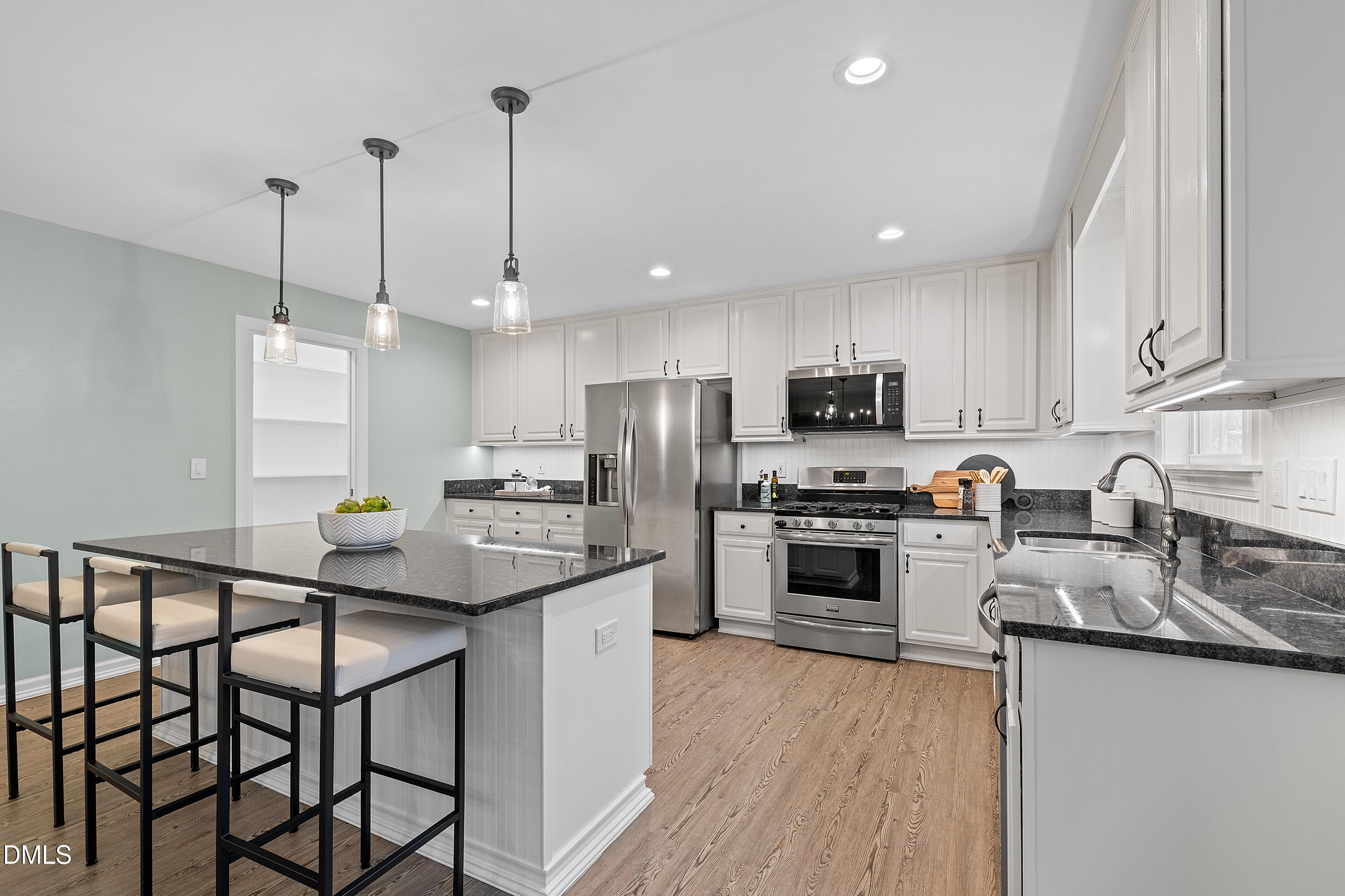 7119 Wexford Woods Trail Raleigh, NC 27613 - Photo 19 of 41 a kitchen with granite countertop a stove a sink a kitchen island with stainless steel appliances