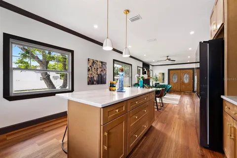 a kitchen with kitchen island a large counter top space a sink stainless steel appliances and cabinets