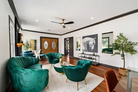a living room with furniture potted plant and a large window