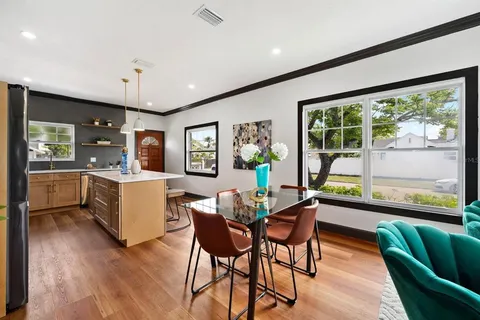 a dining room with furniture and a large window