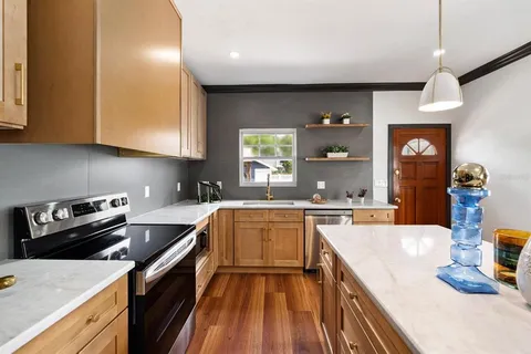 a kitchen with stainless steel appliances granite countertop a sink stove and refrigerator