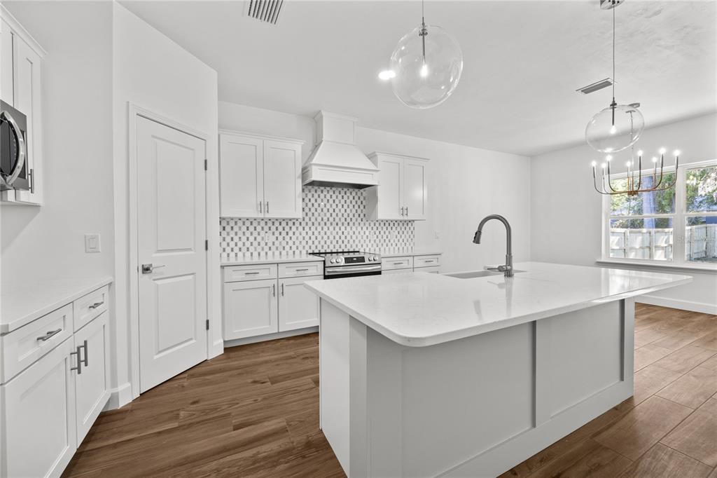 1086 Southwest 67th Drive Gainesville, FL 32607 - Photo 21 of 37 a kitchen with white cabinets appliances and a sink