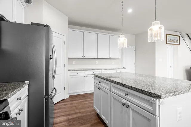 a kitchen with stainless steel appliances granite countertop a sink a stove and a refrigerator