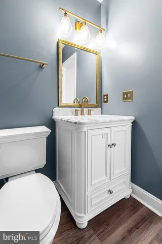 a bathroom with a granite countertop toilet sink and mirror