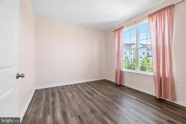 a view of a room with wooden floor and a window