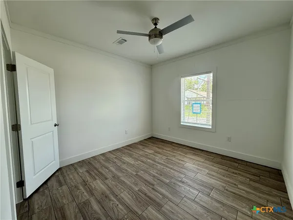 wooden floor in an empty room with a window