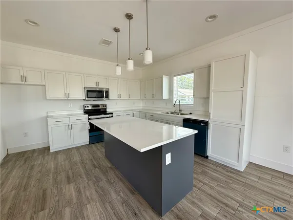 a kitchen with a stove a sink and a refrigerator