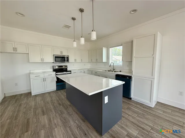 a kitchen with a stove a sink and a refrigerator