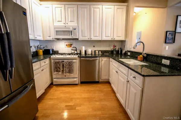 a kitchen with stainless steel appliances granite countertop a stove a sink and a refrigerator