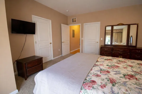 a bedroom with bed and mirror
