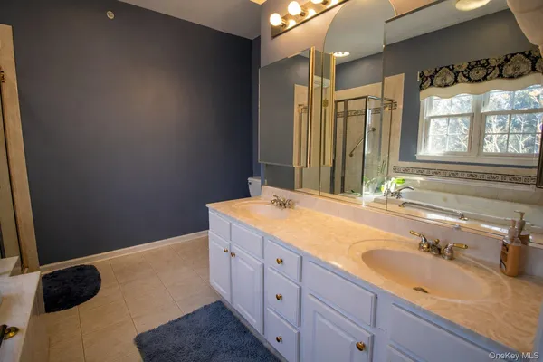 a bathroom with a granite countertop sink and a large mirror