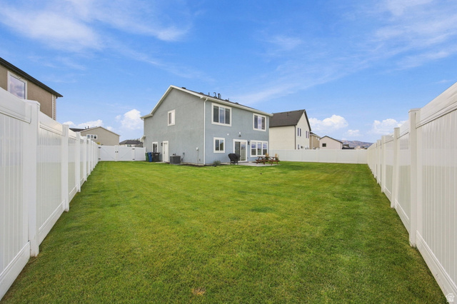 1566 Silver Canoe Loop Logan, UT 84321 - Photo 39 of 44 Expansive backyard featuring a manicured lawn, white vinyl fencing, and a concrete patio