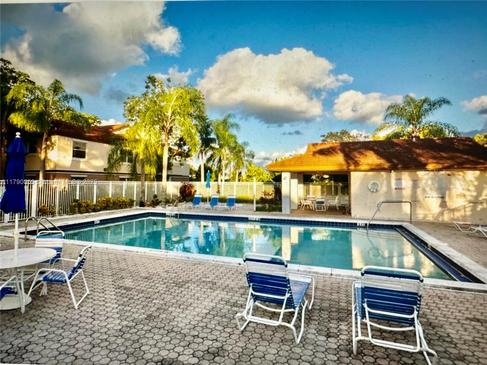 1200 Southwest 113th Terrace, Unit 202 Pembroke Pines, FL 33025 - Photo 14 of 14 a view of a swimming pool with a lounge chairs