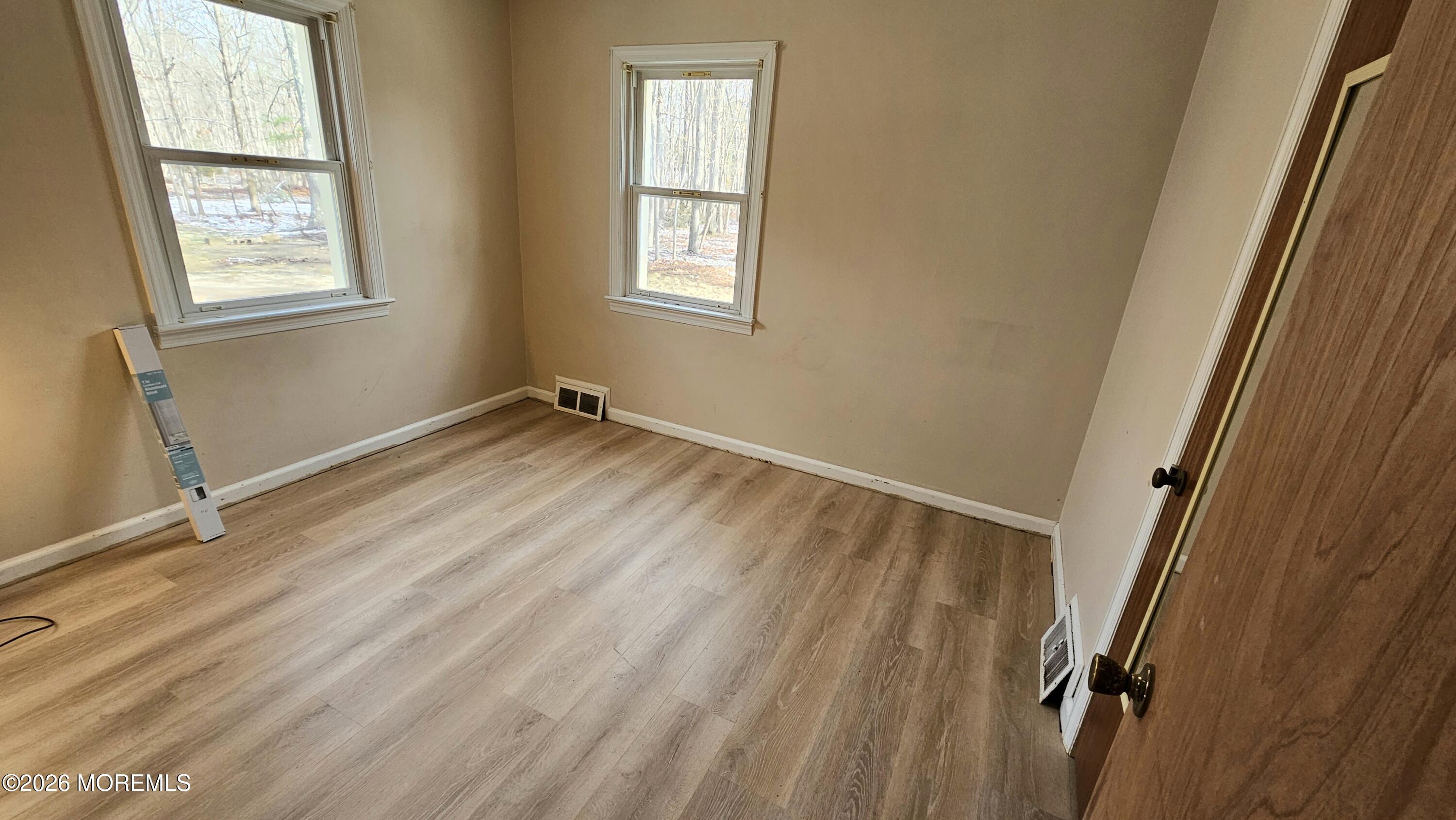 12 Anderson Drive Howell, NJ 07731 - Photo 20 of 26 a view of an empty room with wooden floor and a window