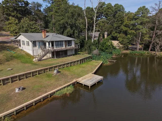 an aerial view of a house with swimming pool and outdoor seating