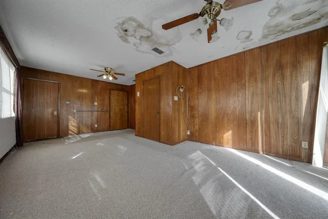 a view of a livingroom with a ceiling fan and hallway