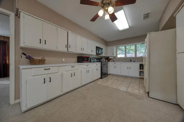 a kitchen with white cabinets and white appliances