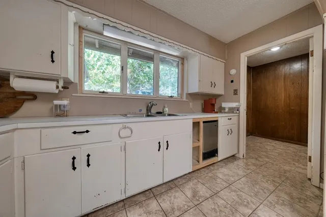 a kitchen with white cabinets and white appliances