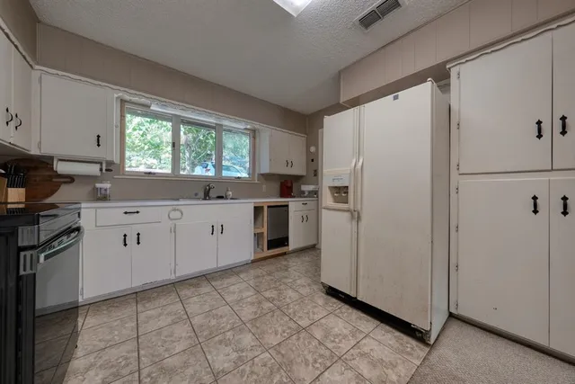 a kitchen with a white cabinets and white stainless steel appliances