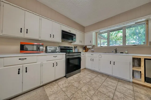a kitchen with white cabinets and white appliances