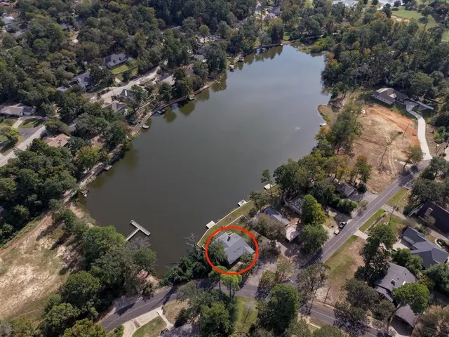 an aerial view of a house with a yard and lake view