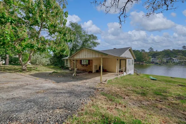 a front view of a house with a yard and lake
