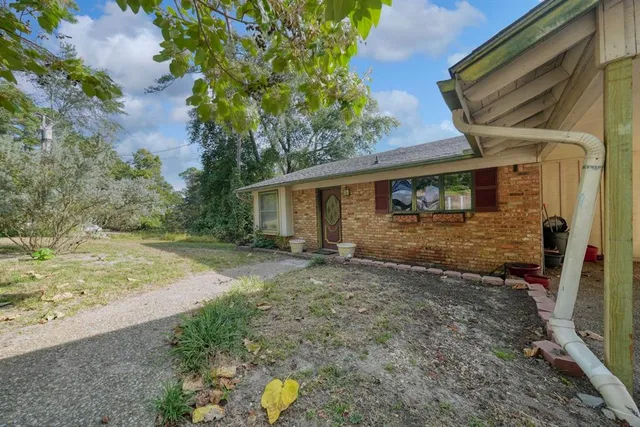 a view of a house with backyard and trees