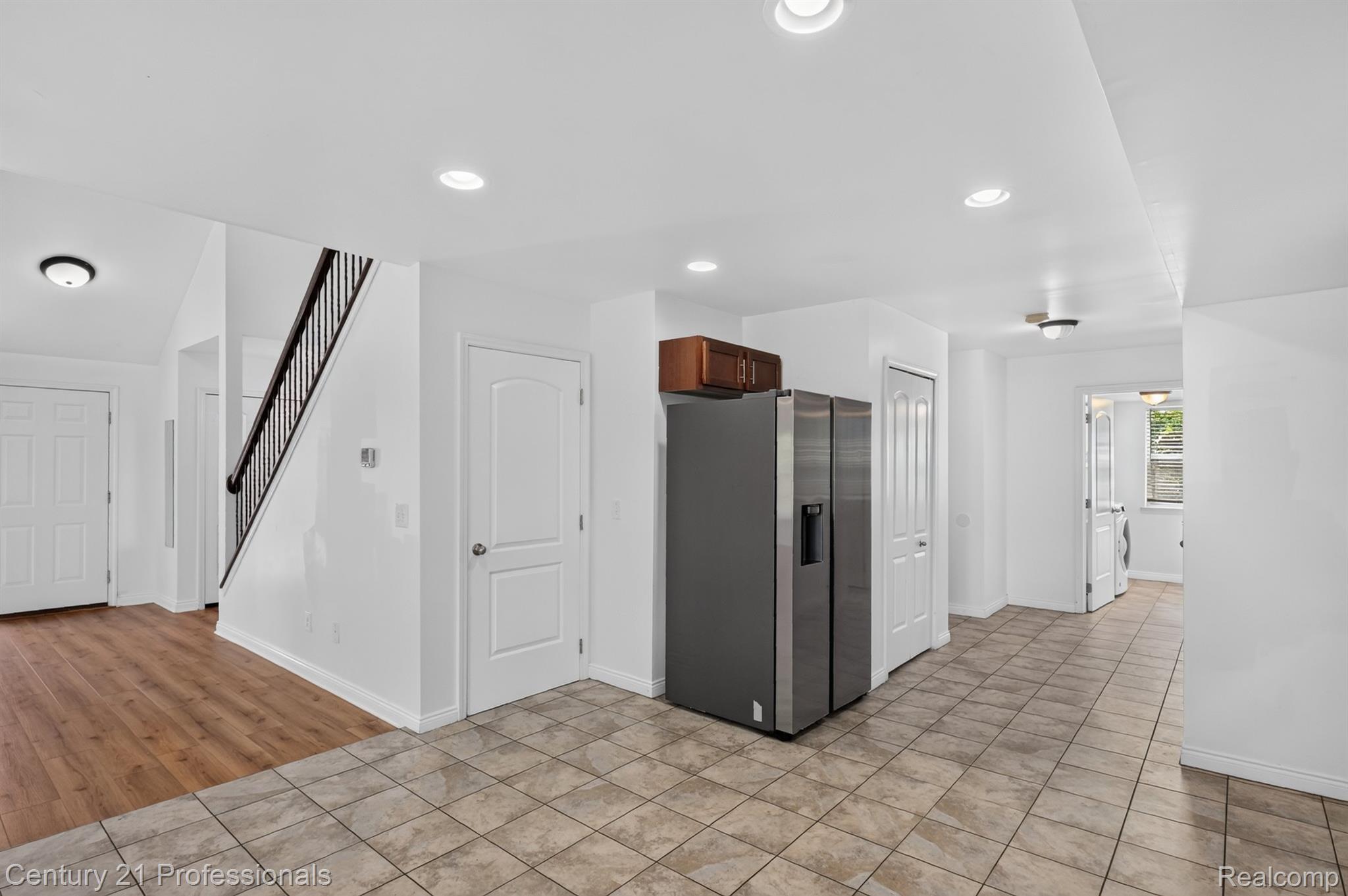 2042 Decker Road Walled Lake, MI 48390 - Photo 16 of 48 Bright interior space featuring a staircase with dark wood-finish handrail and black metal balusters