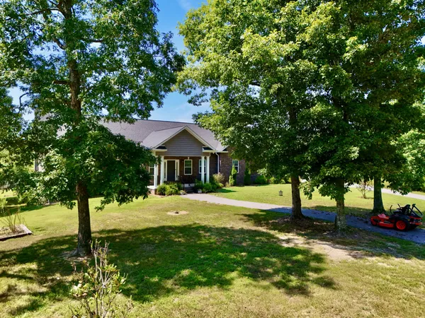 an aerial view of a house with a yard and large trees