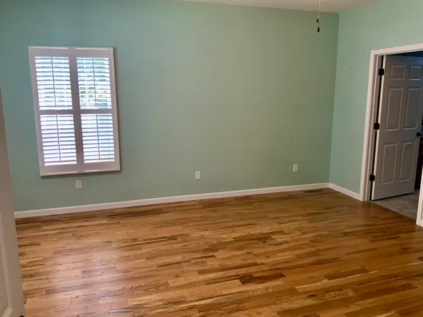 a view of empty room with window and fan